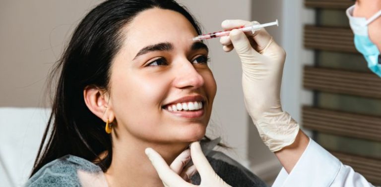 A young woman getting facial filler injections.