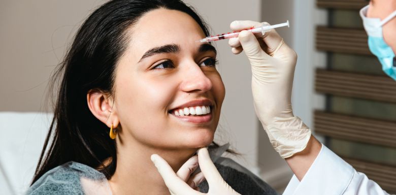 A young woman getting facial filler injections.