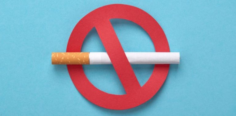 A cigarette with a red X through it on a blue background.