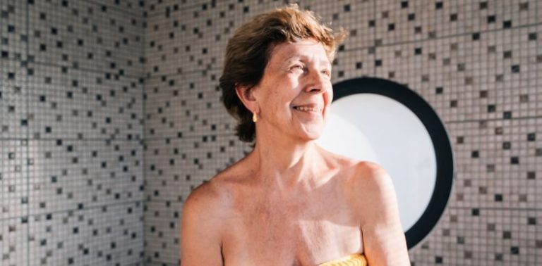 An older woman sitting in a walk in tub